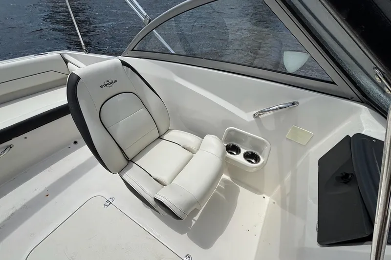 Slide: The Image of 2020 Stingray 191 DC boat interior with white seating and cup holders. - 12