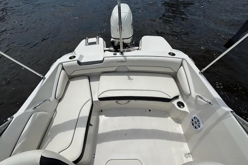 Slide: The Image of 2020 Stingray 191 DC boat interior with seating and outboard motor on water. - 13
