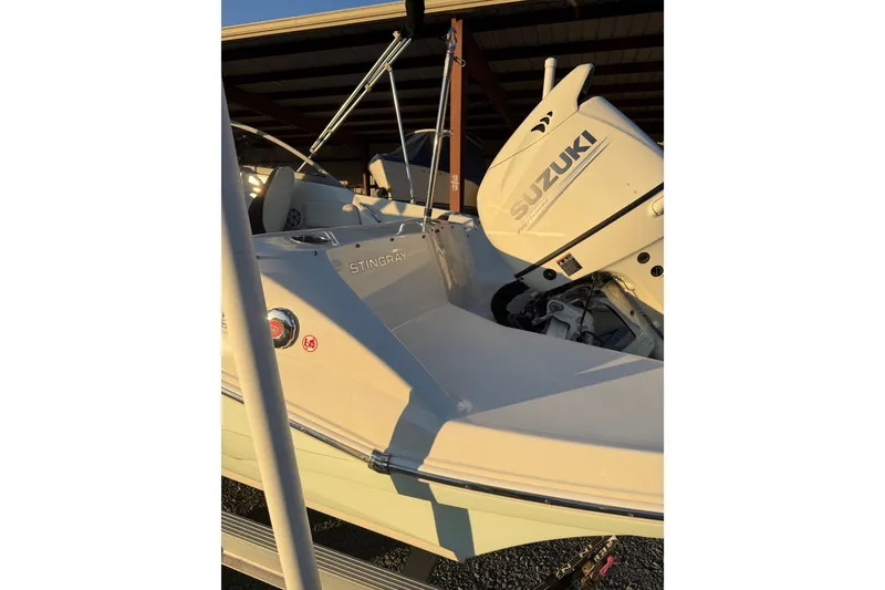 Slide: The Image of 2020 Stingray 191 DC boat with Suzuki outboard motor in storage. - 3