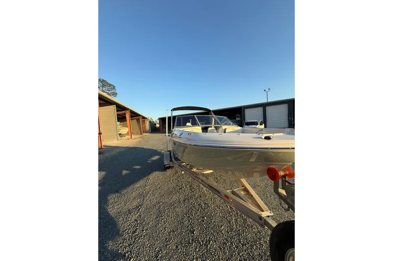 Slide: The Image of 2020 Stingray 191 DC boat on trailer in storage facility under clear sky. - 5