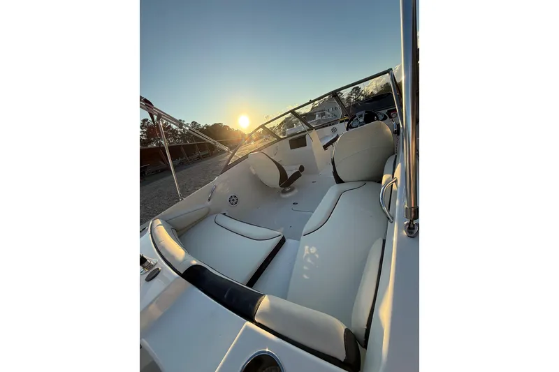 Slide: The Image of 2020 Stingray 191 DC boat interior at sunset, featuring sleek white seating and dashboard. - 7