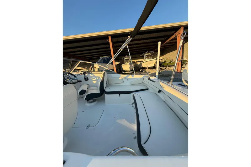 Slide: The Image of 2020 Stingray 191 DC boat interior with seating and steering wheel under a canopy. - 8
