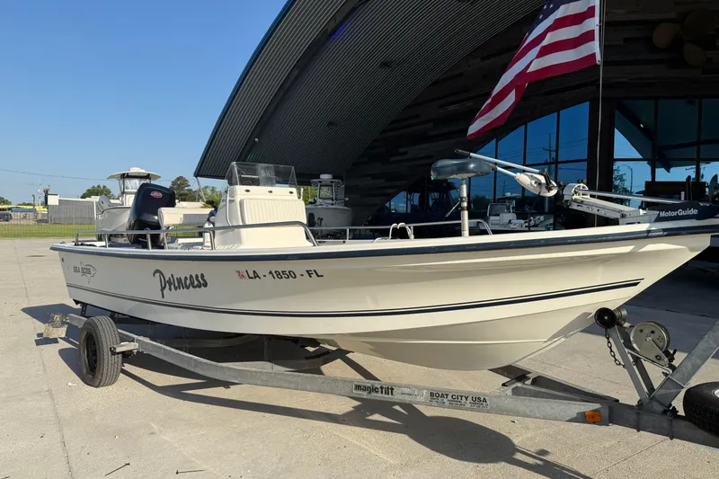 Slide: The Image of 2006 Sea Boss 21 Bay Boat on trailer, named "Princess," with American flag in background. - 3