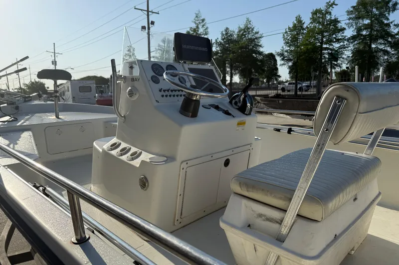 Slide: The Image of 2006 Sea Boss 21 Bay Boat interior with steering console and seating, under clear sky. - 7
