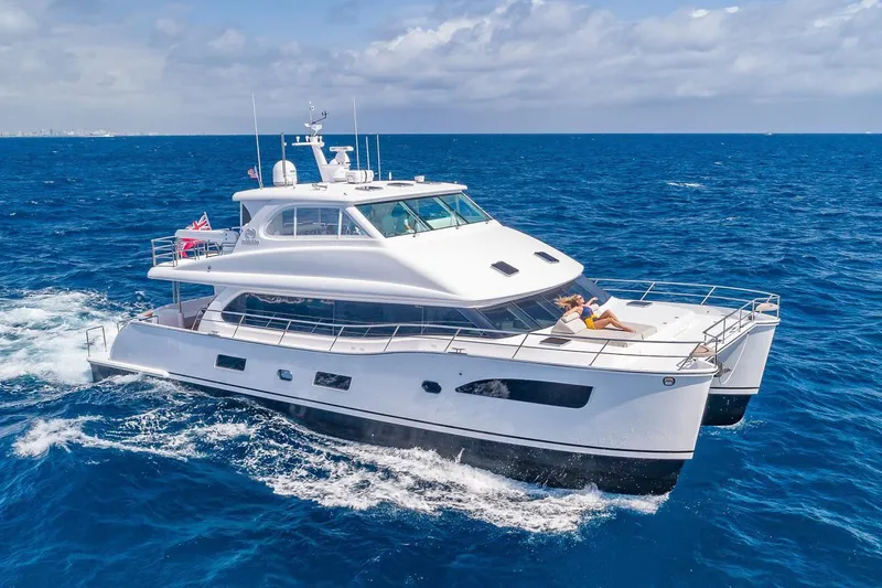 Slide: The Image of Manufacturer Provided Image: 2022 Horizon PC65 yacht cruising on the ocean with a person sunbathing on the deck. - 11