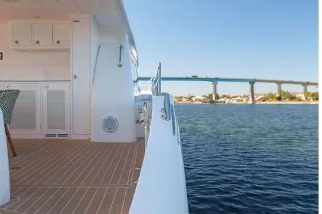 Slide: The Image of 2022 Horizon PC65 yacht deck with scenic bridge view over calm water. - 17