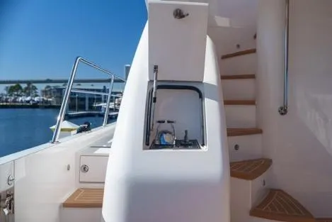 Slide: The Image of Luxury yacht Horizon PC65, 2022 model, featuring sleek outdoor staircase and compact sink area. - 22