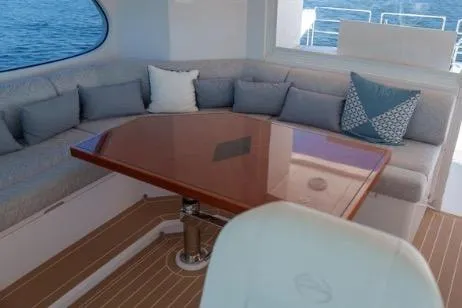 Slide: The Image of Luxurious seating area on 2022 Horizon PC65 yacht with elegant cushions and wooden table. - 37