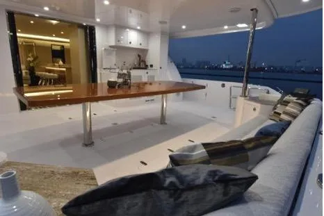 Slide: The Image of Luxurious 2022 Horizon PC65 yacht deck with elegant seating and dining area at dusk. - 44