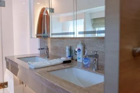 Slide: The Image of Modern bathroom with dual sinks, mirrors, and toiletries on a marble countertop in a Horizon PC65 yacht. - 91