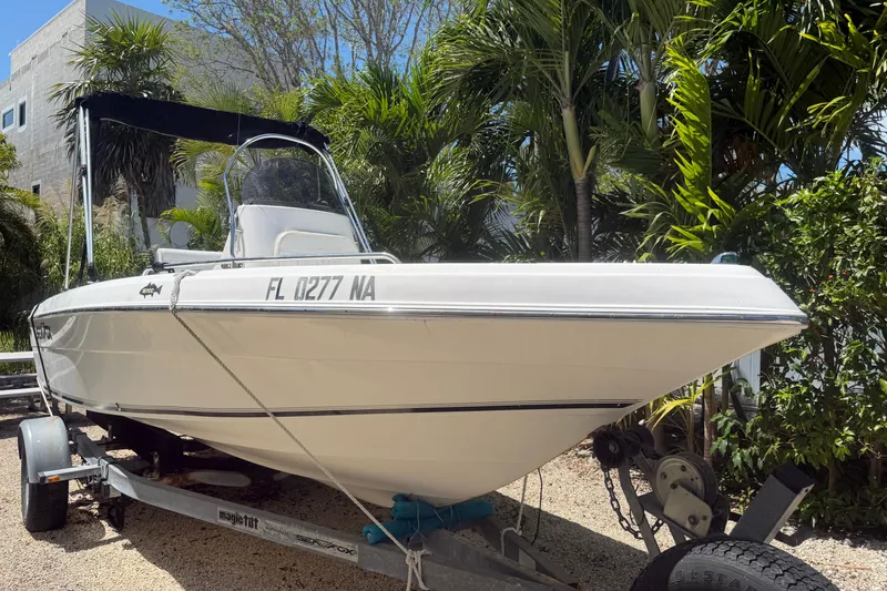 The Image of 2006 Sea Fox 187 Center Console boat on trailer, surrounded by lush greenery. - 0