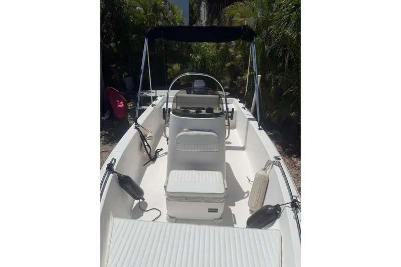 Slide: The Image of 2006 Sea Fox 187 Center Console boat with seating and canopy, surrounded by lush greenery. - 16