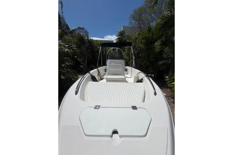 Slide: The Image of 2006 Sea Fox 187 Center Console boat with white deck, surrounded by lush greenery. - 3