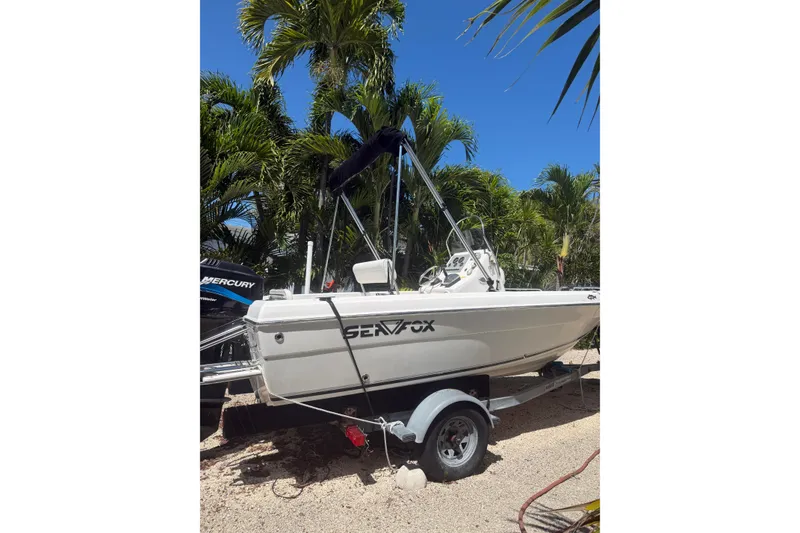 Slide: The Image of 2006 Sea Fox 187 Center Console boat on trailer, surrounded by palm trees. - 6