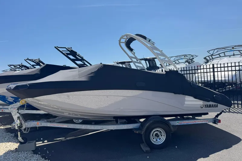 Slide: The Image of 2026 Yamaha Boats 195S covered on trailer, parked outdoors under clear sky. - 10