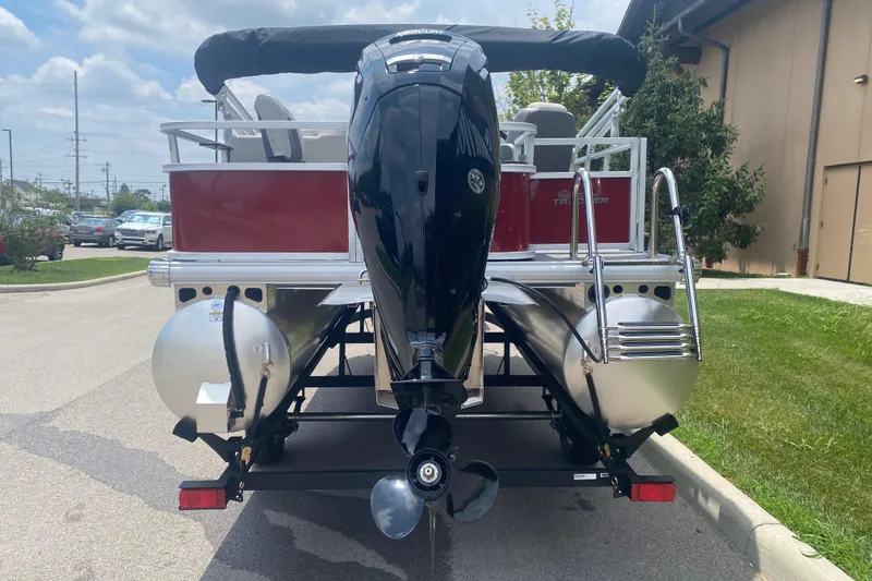 Slide: The Image of 2026 Sun Tracker Bass Buggy 18 DLX pontoon boat with outboard motor, parked outdoors. - 10