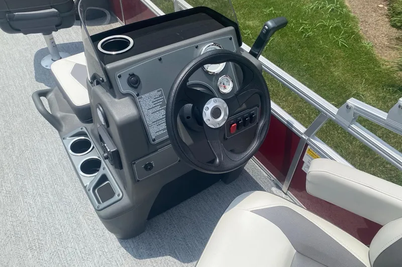 Slide: The Image of 2026 Sun Tracker Bass Buggy 18 DLX steering console with cup holders and gauges. - 7