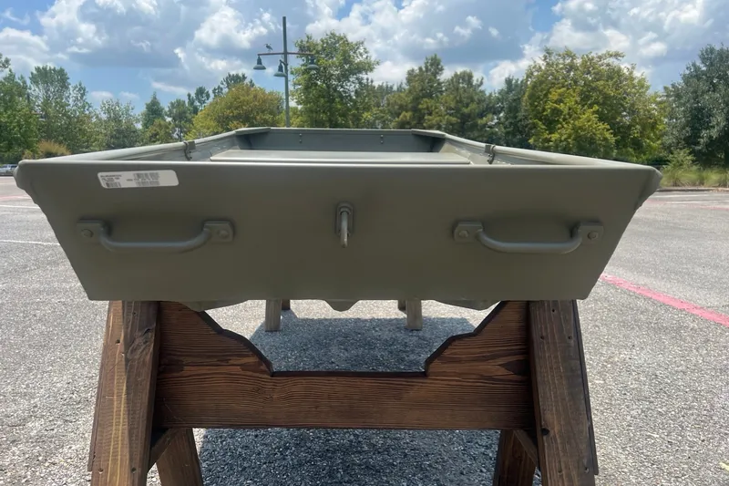 Slide: The Image of 2026 Tracker Grizzly 10 Jon boat displayed on wooden stand outdoors. - 4