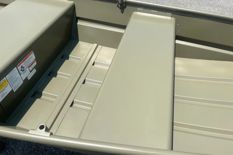Slide: The Image of 2026 Tracker Grizzly 10 Jon boat interior with bench seating and safety labels. - 7
