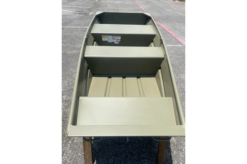 Slide: The Image of 2026 Tracker Grizzly 10 Jon boat on pavement, showcasing interior seating and design. - 5