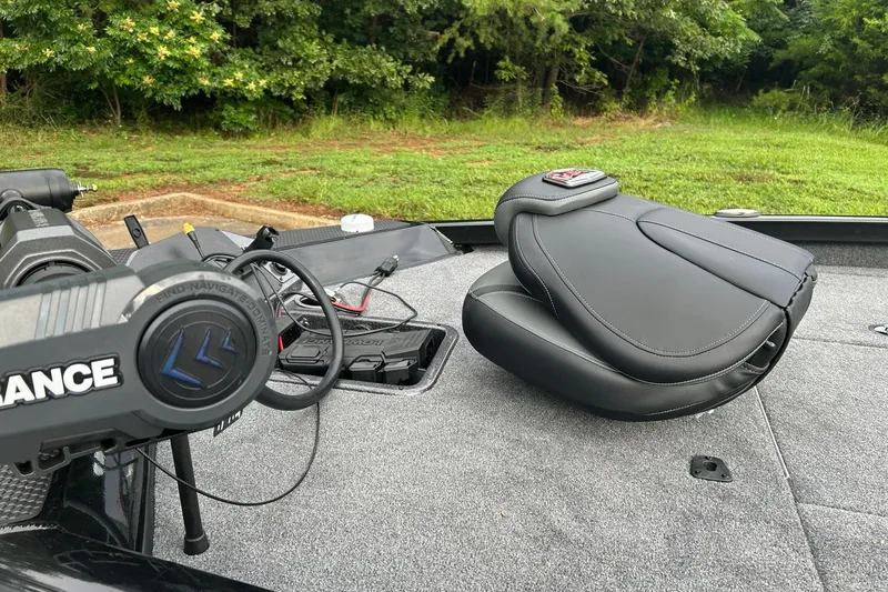 Slide: The Image of 2026 Ranger RT198P boat interior with steering wheel and seat, surrounded by greenery. - 6