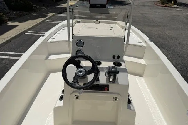 Slide: The Image of 2026 Mako Pro Skiff 19 CC boat interior with steering wheel and console controls. - 5