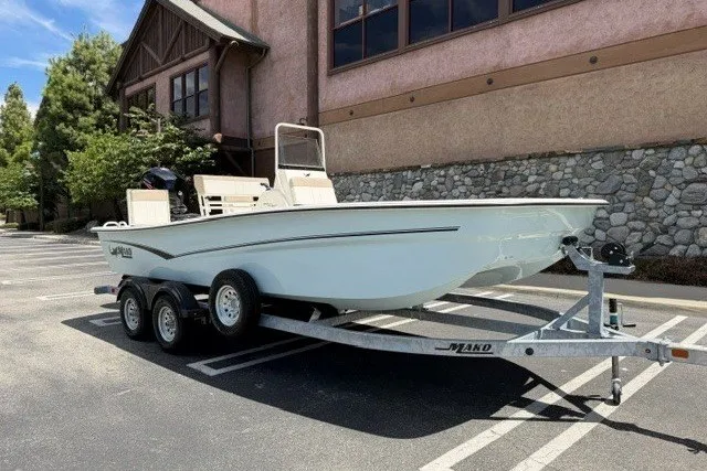Slide: The Image of 2026 Mako Pro Skiff 19 CC boat on trailer in parking lot. - 2