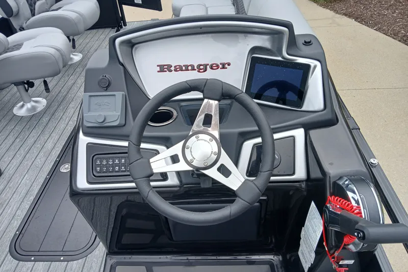 Slide: The Image of 2026 Ranger 223FC boat dashboard with steering wheel, control panel, and touchscreen display. - 2