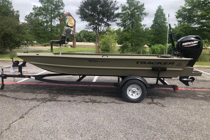 The Image of 2026 Tracker Grizzly 1654 T Sportsman boat on trailer in parking lot. - 0