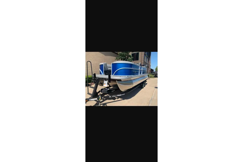 Slide: The Image of 2026 Sun Tracker Party Barge 22 XP3 pontoon boat on trailer, parked outdoors. - 26