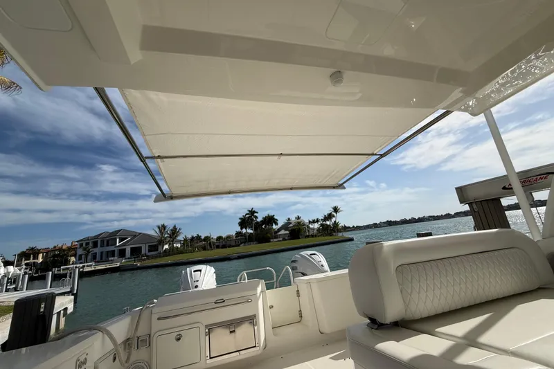 Slide: The Image of 2021 World Cat 400 DC-X boat interior with sunshade, overlooking waterfront homes and palm trees. - 17