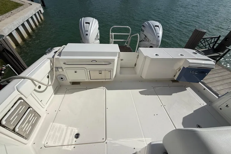Slide: The Image of World Cat 400 DC-X 2021 boat deck with twin engines, docked by the water. - 21