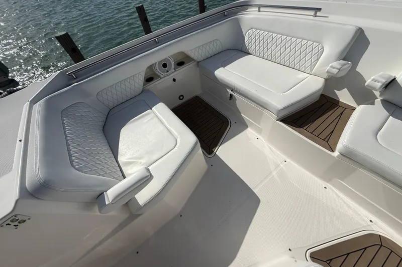 Slide: The Image of Luxurious seating area on a 2021 World Cat 400 DC-X boat, featuring white cushioned seats. - 29