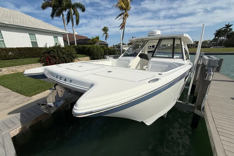 Slide: The Image of 2021 World Cat 400 DC-X boat docked by waterfront home, palm trees in background. - 3