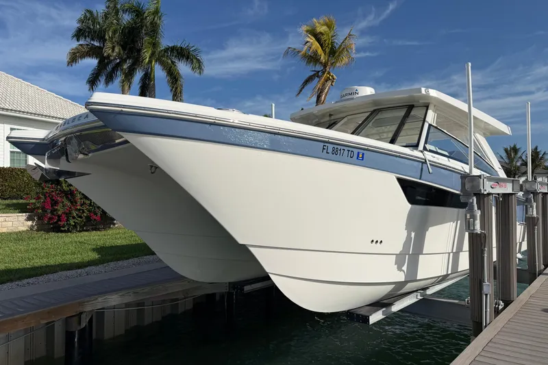 Slide: The Image of 2021 World Cat 400 DC-X boat docked, surrounded by palm trees and clear skies. - 4