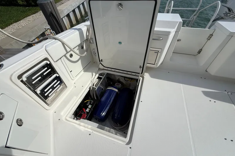 Slide: The Image of Open storage compartment on 2021 World Cat 400 DC-X boat deck, revealing equipment inside. - 9