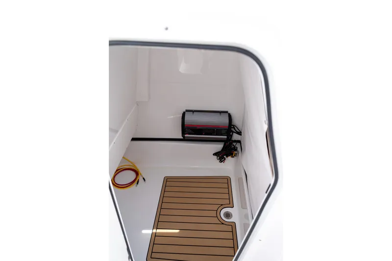 Slide: The Image of 2026 Sportsman Masters 247 Bay Boat storage compartment with charger and wiring. - 23