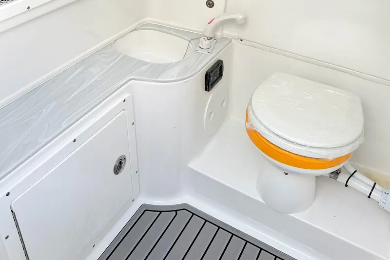 Slide: The Image of 2026 Sea Hunt Gamefish 30 boat bathroom with compact toilet and sink. - 19