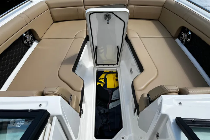 Slide: The Image of 2019 Sea Ray SDX 270 boat interior with open storage compartment and beige seating. - 10