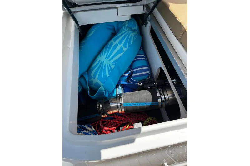 Slide: The Image of Storage compartment of 2019 Sea Ray SDX 270 boat with blue inflatables and equipment. - 19