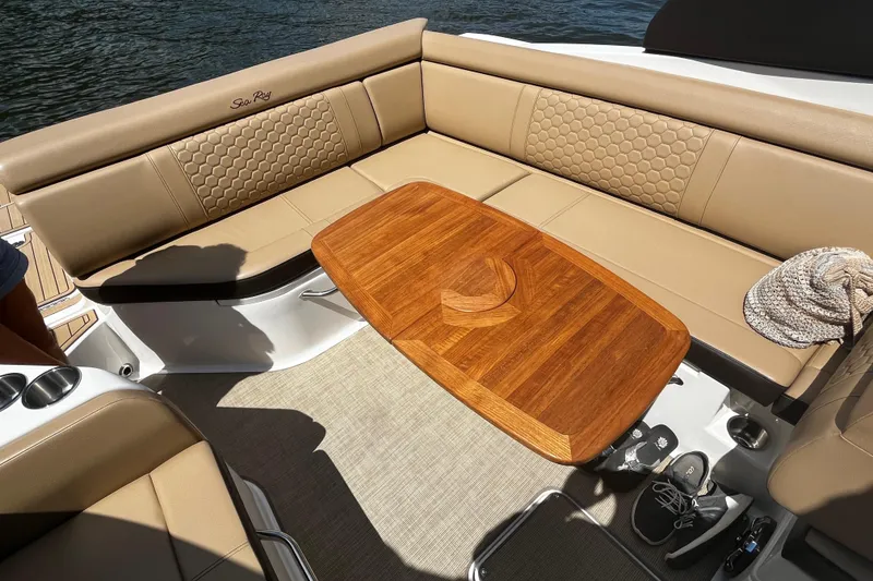 Slide: The Image of Luxurious 2019 Sea Ray SDX 270 boat interior with tan seating and wooden table. - 21