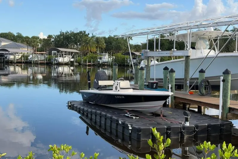 Slide: The Image of 2008 Maverick 21 Master Angler boat docked on a serene waterfront with lush greenery. - 10
