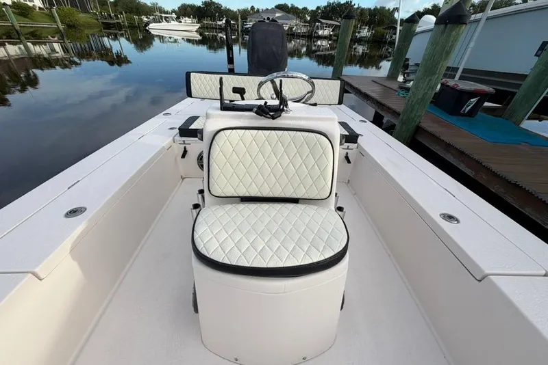 Slide: The Image of 2008 Maverick 21 Master Angler boat interior with white quilted seating, docked by calm water. - 2