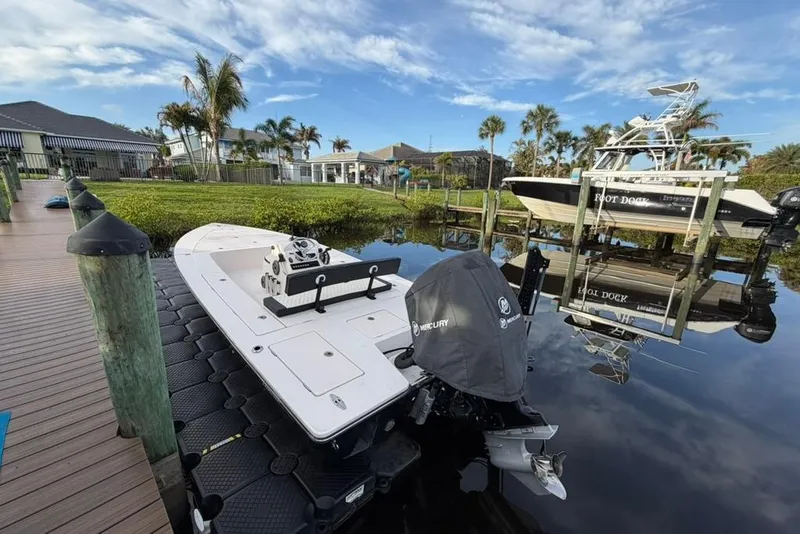 Slide: The Image of 2008 Maverick 21 Master Angler boat docked by a scenic waterfront with palm trees. - 8