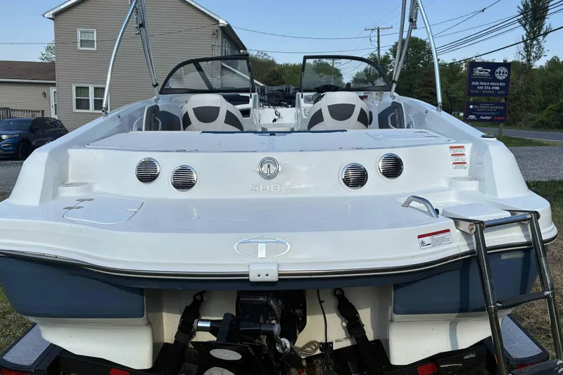 Slide: The Image of 2021 Tahoe 500 TF boat, rear view, parked outdoors with visible ladder and seating. - 5