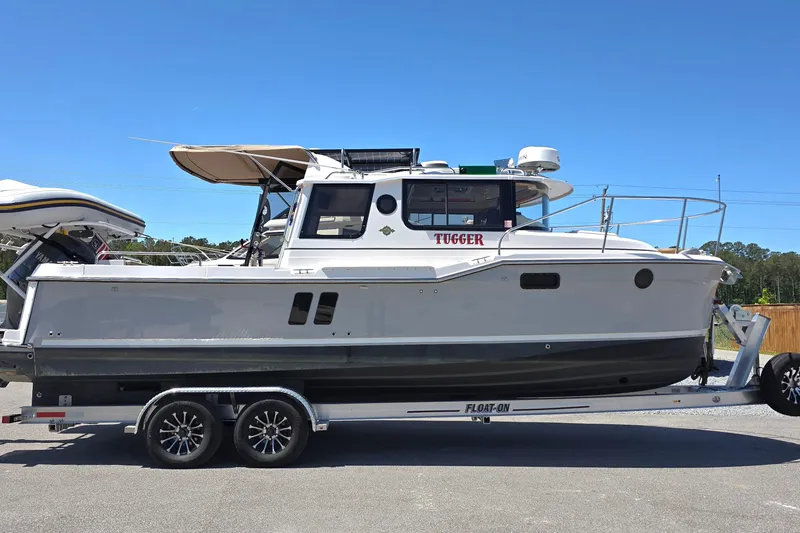The Image of 2025 Ranger Tugs R-25 boat on trailer under clear blue sky. - 0