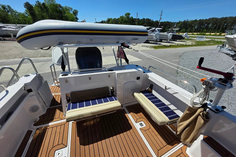 Slide: The Image of 2025 Ranger Tugs R-25 boat deck with seating and inflatable dinghy, docked outdoors. - 11