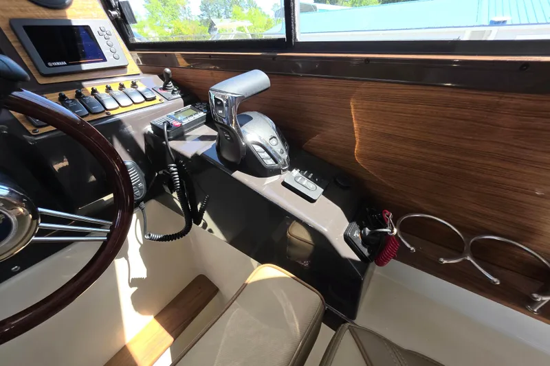Slide: The Image of Interior helm of 2025 Ranger Tugs R-25 boat with modern controls and wood accents. - 13