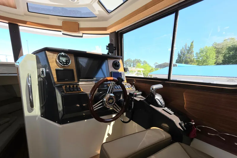 Slide: The Image of Interior of 2025 Ranger Tugs R-25 boat, featuring modern helm and navigation controls. - 14