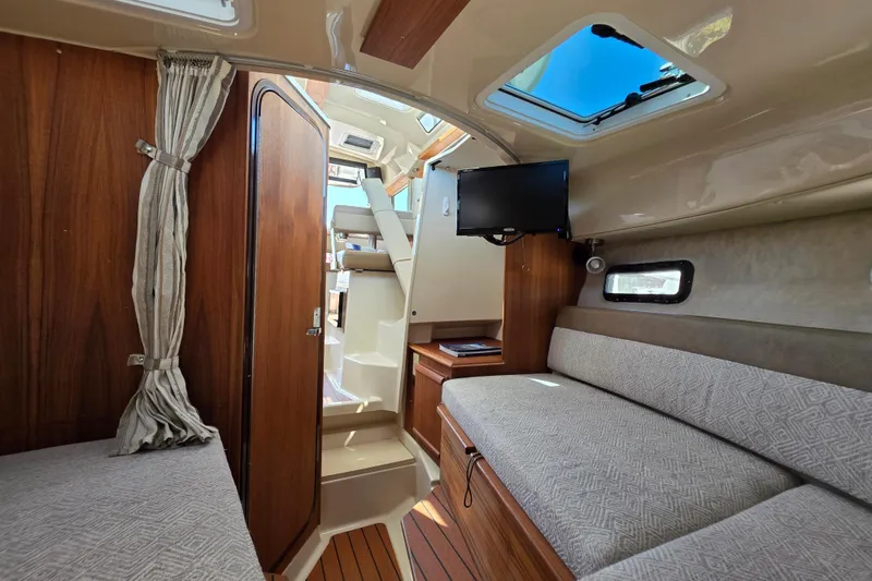 Slide: The Image of Interior of 2025 Ranger Tugs R-25 boat with cozy seating and modern amenities. - 15